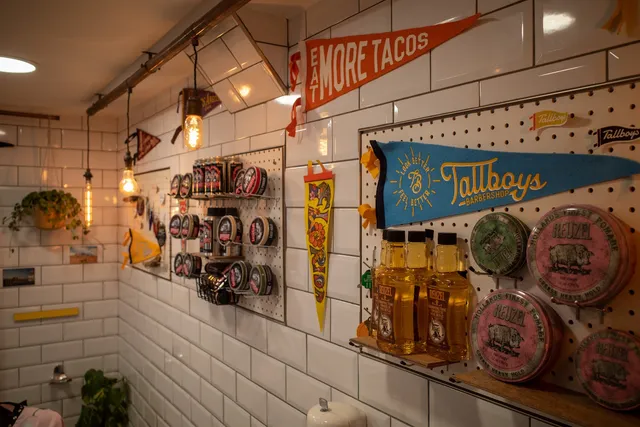 The product wall at Tallboys — Reuzel pomades and pennants