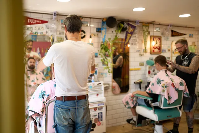 Inside Tallboys — mint-green vintage chairs and a wall of postcards