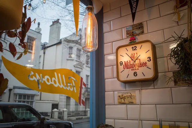 Festoon bulbs and a vintage Old Milwaukee clock in the Tallboys window